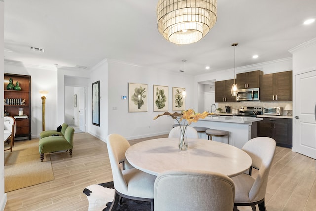 dining room featuring crown molding and light hardwood / wood-style flooring