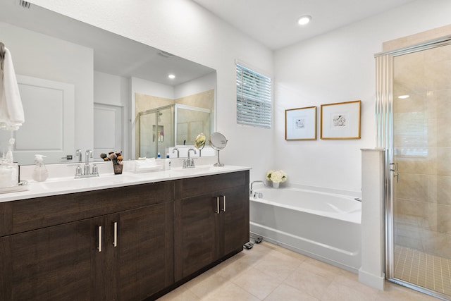 bathroom featuring plus walk in shower, vanity, and tile patterned floors