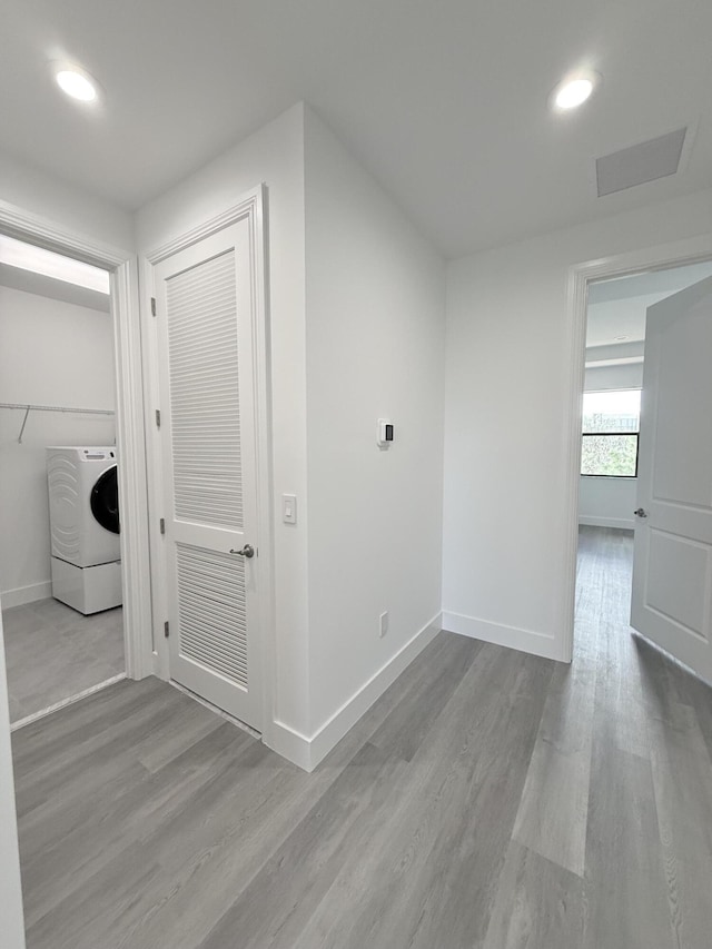 hall featuring light wood-type flooring and washer / dryer