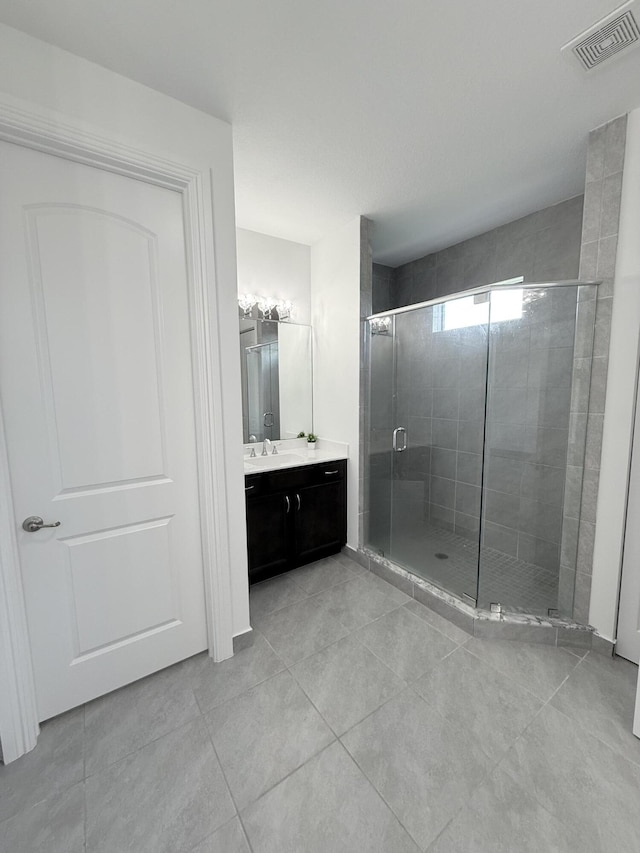 bathroom featuring tile patterned flooring, vanity, and a shower with door