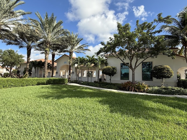 mediterranean / spanish home with a front lawn