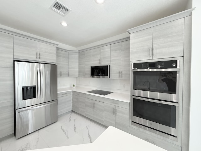 kitchen with a textured ceiling and appliances with stainless steel finishes