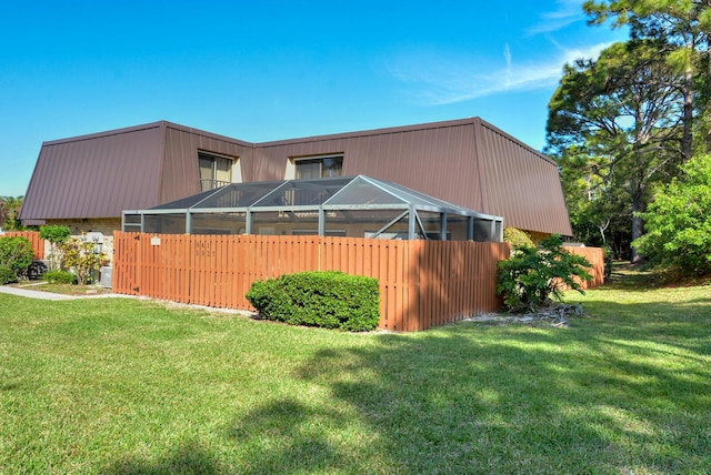 view of side of home featuring a yard and a lanai