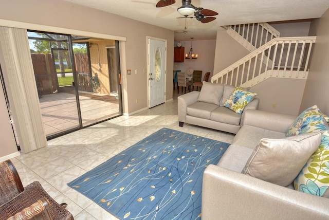 living room with ceiling fan with notable chandelier