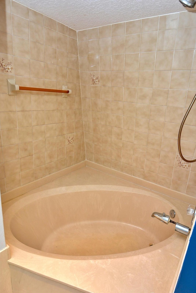 bathroom with a bathing tub and a textured ceiling