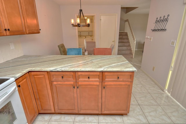 kitchen with a notable chandelier, light tile patterned flooring, light stone countertops, and independent washer and dryer