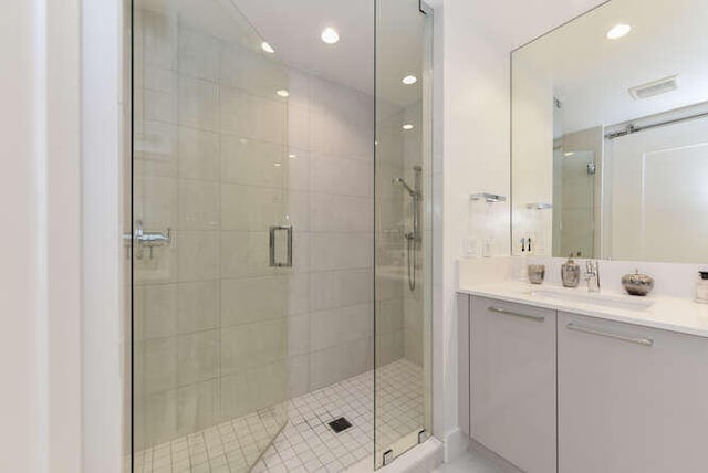 bathroom with vanity and a shower with door