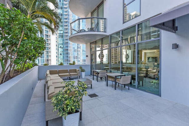 view of patio with outdoor lounge area and a balcony