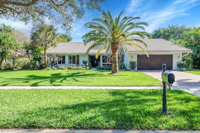 view of front of house with a garage and a front lawn