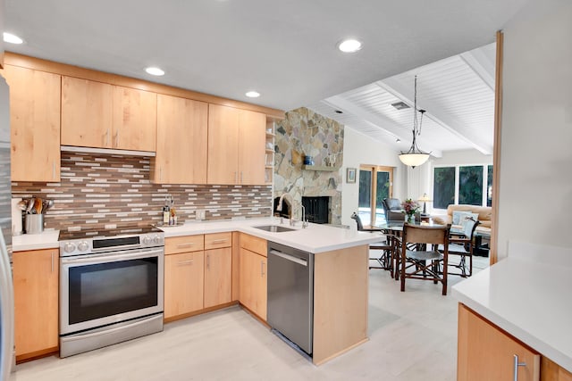 kitchen featuring light brown cabinets, sink, kitchen peninsula, decorative light fixtures, and appliances with stainless steel finishes