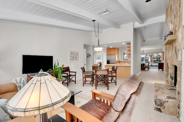 living room featuring a fireplace, beam ceiling, and sink