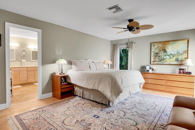 bedroom featuring light hardwood / wood-style floors, ensuite bath, and ceiling fan