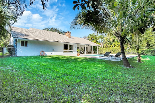 rear view of house with a lawn and a patio area