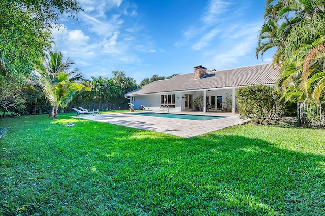 back of property featuring ceiling fan, a patio area, and a lawn