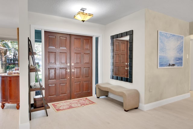 foyer entrance featuring a textured ceiling and light hardwood / wood-style flooring