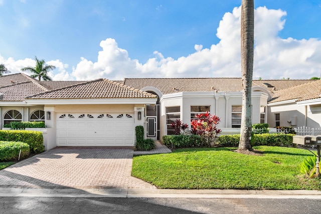 mediterranean / spanish-style home with a garage and a front lawn