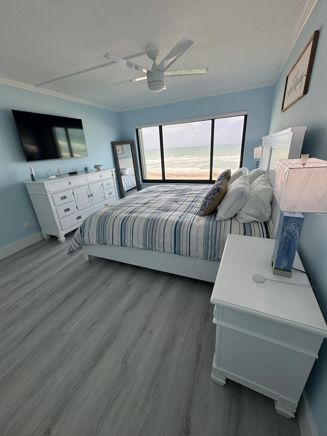 bedroom with wood-type flooring, ceiling fan, and ornamental molding