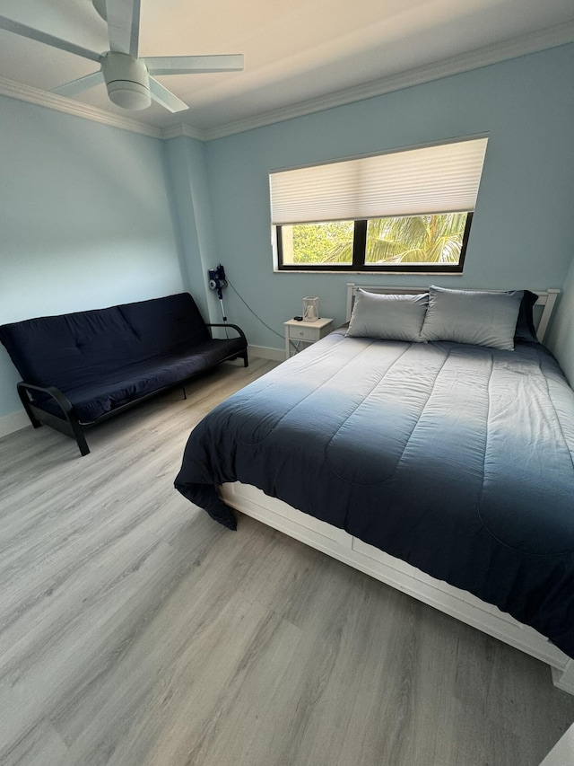 bedroom featuring ceiling fan, light hardwood / wood-style flooring, and crown molding