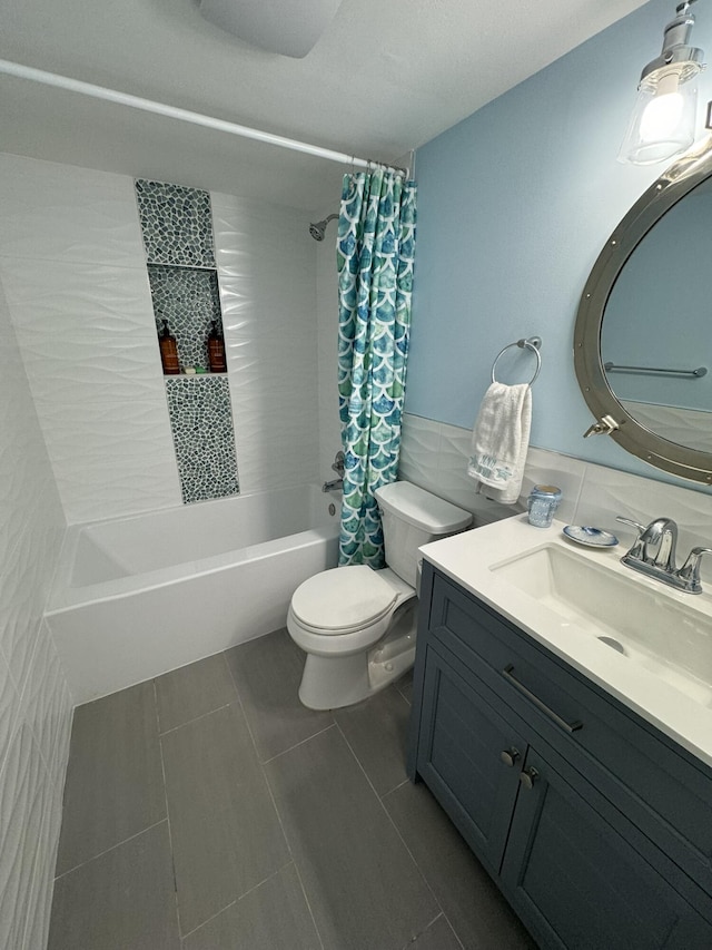 full bathroom with shower / tub combo, vanity, tile walls, tile patterned flooring, and toilet