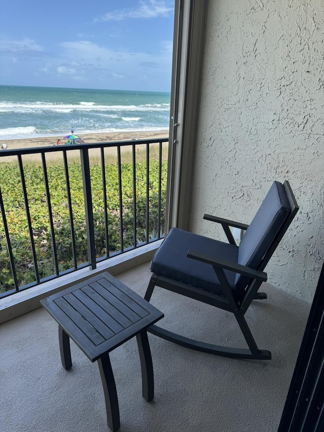 balcony featuring a water view and a view of the beach