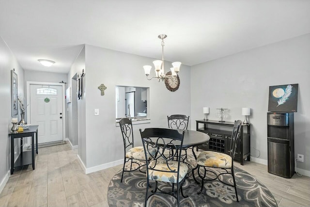 dining area with light hardwood / wood-style floors and a chandelier