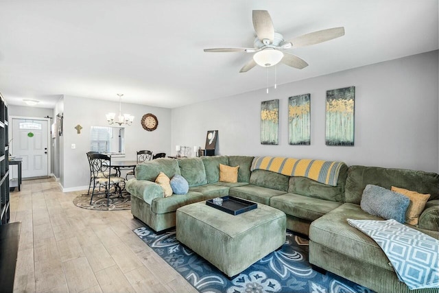 living room featuring ceiling fan with notable chandelier and light wood-type flooring