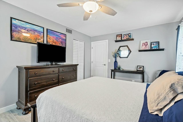 bedroom with a closet, light hardwood / wood-style flooring, and ceiling fan