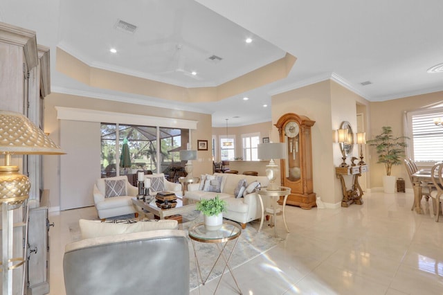 tiled living room featuring plenty of natural light, ceiling fan, a raised ceiling, and ornamental molding