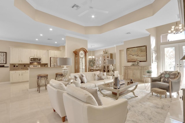 living room with french doors, ceiling fan with notable chandelier, and crown molding