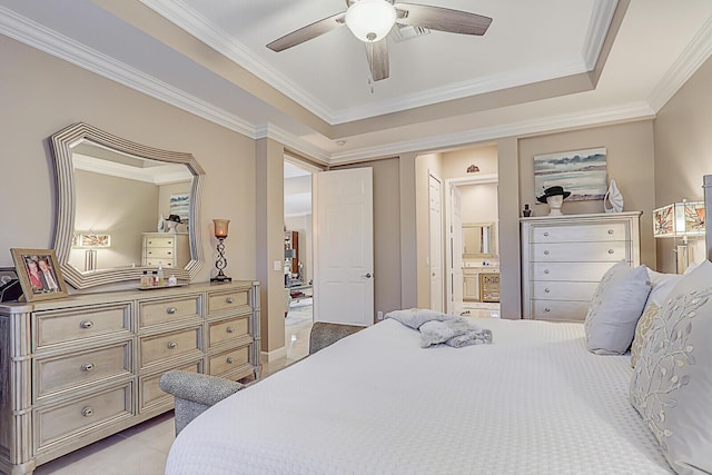 bedroom featuring ceiling fan, a raised ceiling, crown molding, and connected bathroom