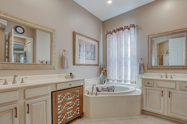 bathroom with tile patterned flooring, vanity, and tiled tub