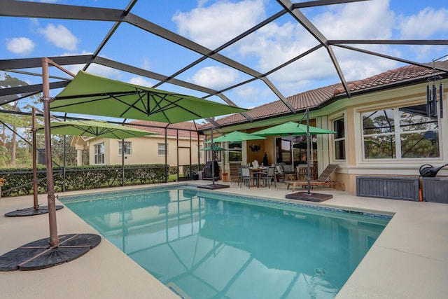 view of swimming pool with glass enclosure and a patio area