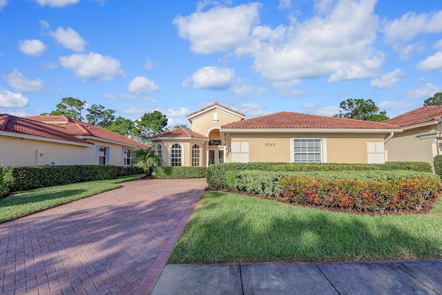 mediterranean / spanish home with a front yard