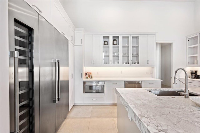 kitchen with appliances with stainless steel finishes, white cabinetry, and sink