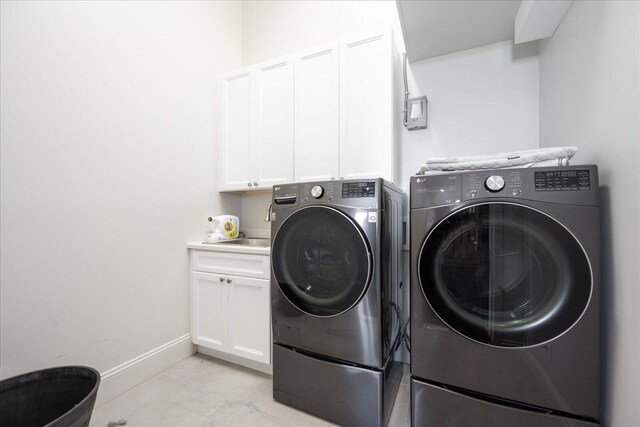 laundry room featuring washer and dryer and cabinets