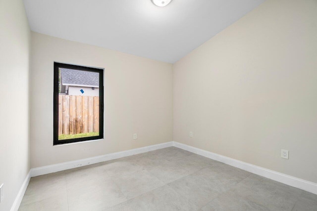 unfurnished room featuring lofted ceiling