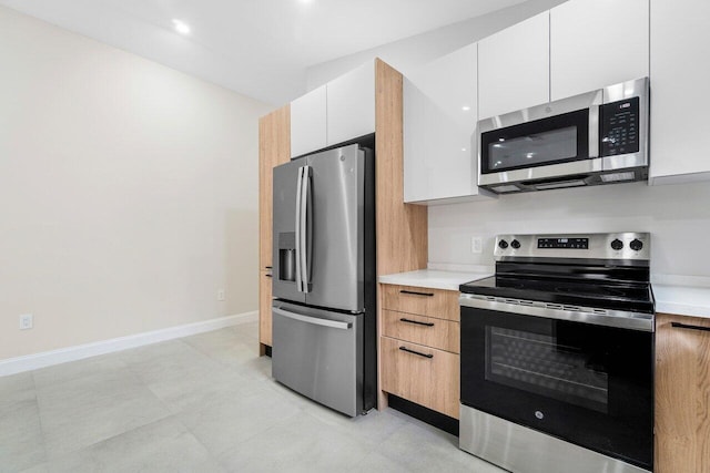 kitchen with white cabinets and appliances with stainless steel finishes