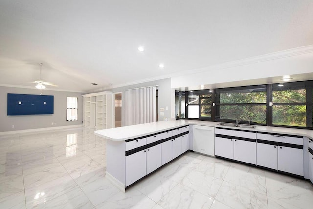 kitchen with kitchen peninsula, ornamental molding, white dishwasher, sink, and white cabinetry