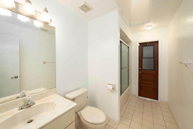 full bathroom featuring shower / bath combination with glass door, vanity, tile patterned flooring, and toilet