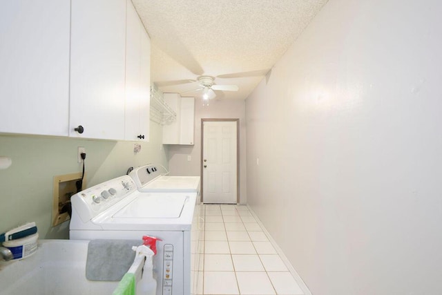 laundry area featuring cabinets, sink, separate washer and dryer, a textured ceiling, and light tile patterned floors