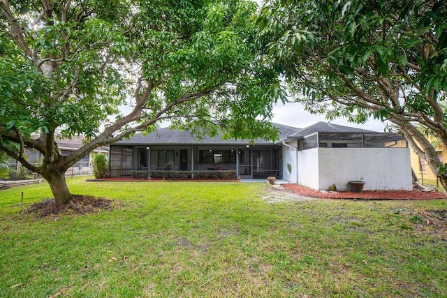 rear view of property featuring a yard and a sunroom