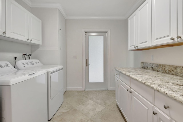 clothes washing area featuring cabinets, ornamental molding, and washing machine and clothes dryer