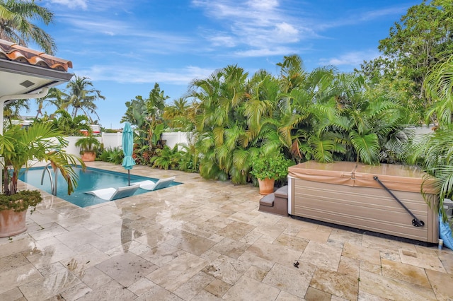 view of swimming pool with a patio area and a hot tub