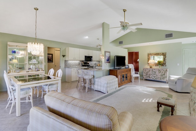 living room featuring light tile patterned floors, ceiling fan with notable chandelier, and high vaulted ceiling