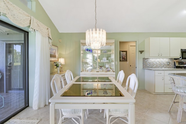 tiled dining area with lofted ceiling and a chandelier