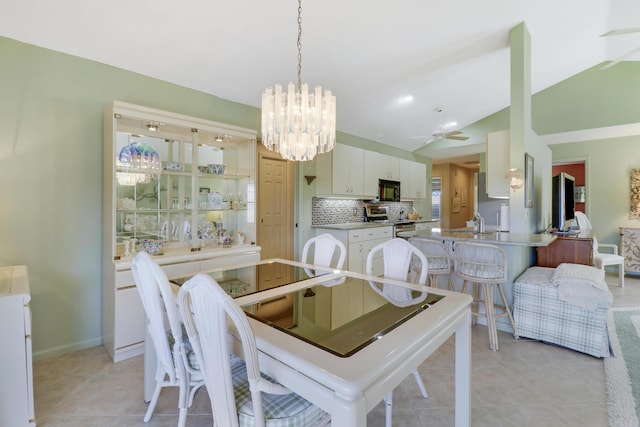 tiled dining area with ceiling fan with notable chandelier, lofted ceiling, and sink