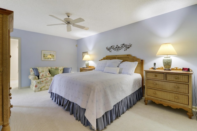 carpeted bedroom featuring ceiling fan and a textured ceiling