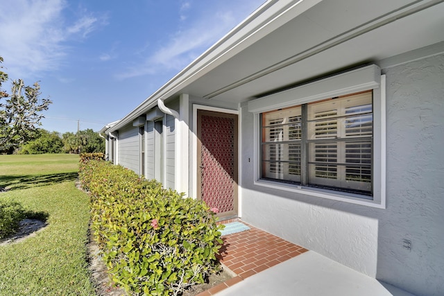 doorway to property with a lawn