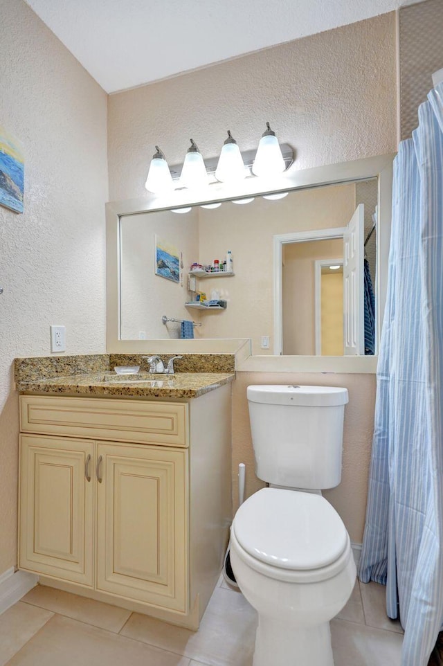 bathroom featuring tile patterned flooring, vanity, and toilet