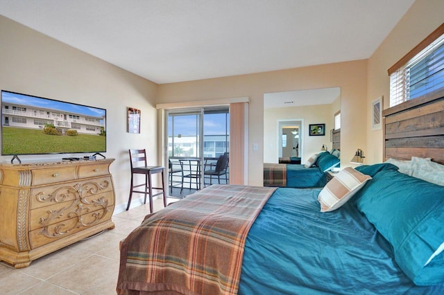 bedroom featuring light tile patterned floors, access to outside, and multiple windows